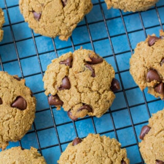 Protein Cookies on a cooling rack with a blue background.