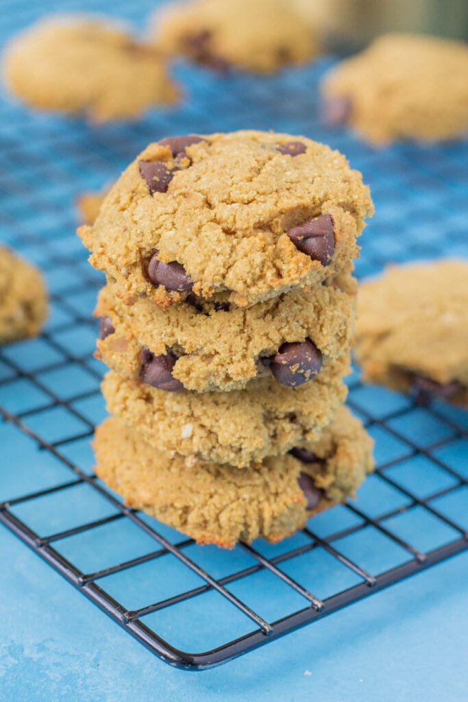 Peanut Butter Protein Cookies stacked on a baking cooling rack.