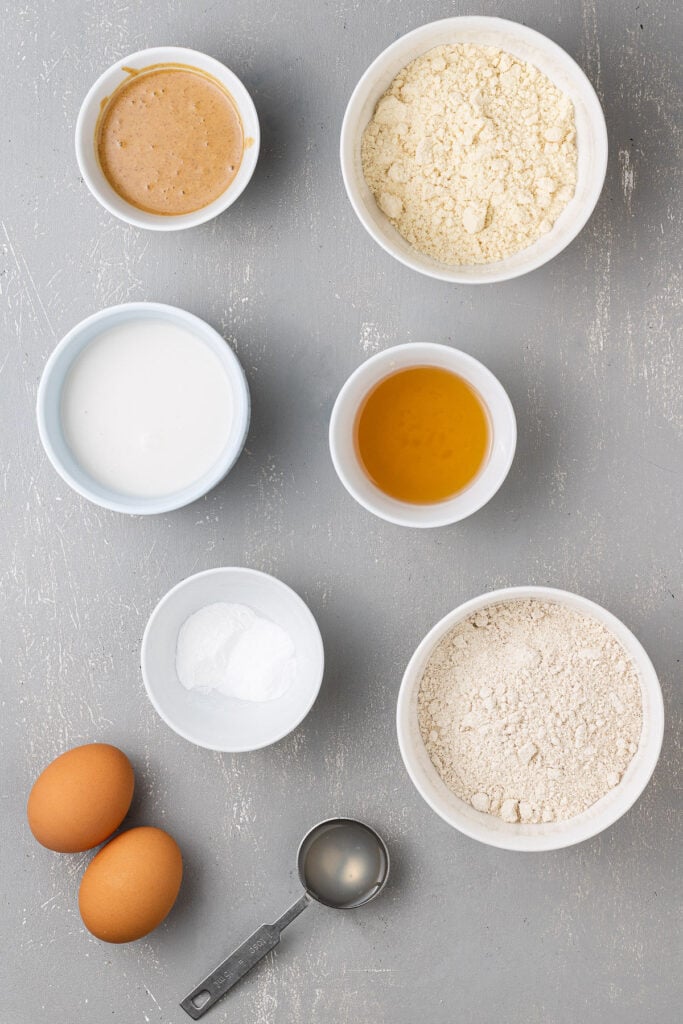 Ingredients for Protein Donuts in small white bowls on a grey background