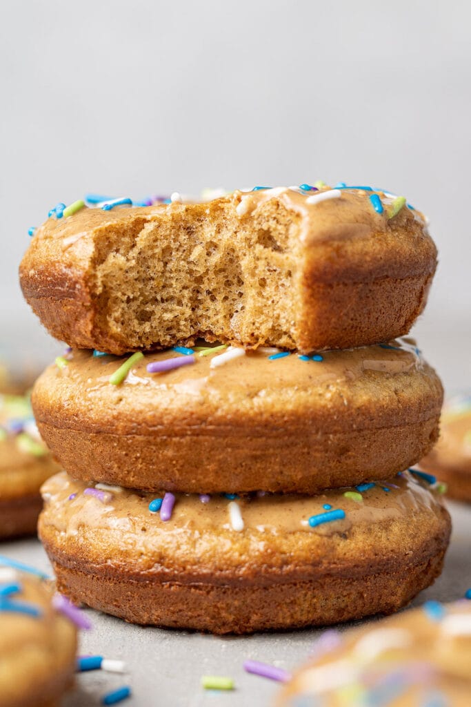 A close up of healthy protein donuts stacked together on a grey background