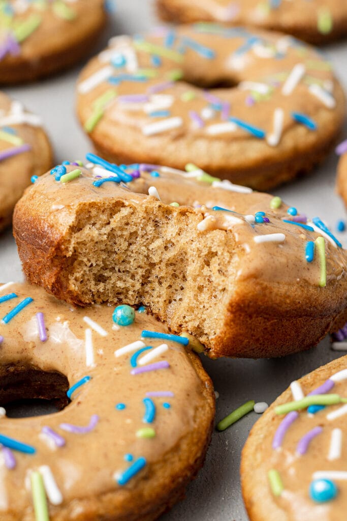 A protein donut with a bite taken out of it stacked against another protein donut