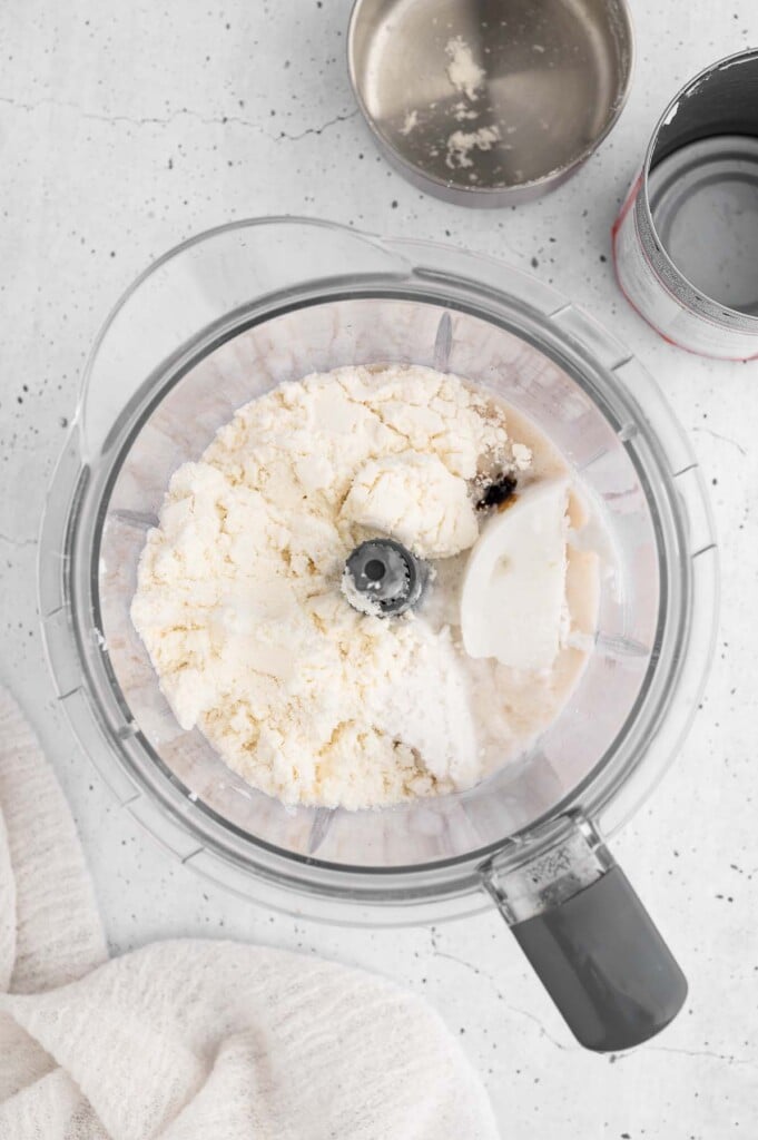 Ingredients for protein ice cream in a blender before blending on a white background
