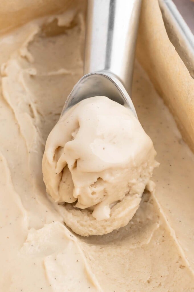 An ice cream scoop scooping out some vanilla protein ice cream 