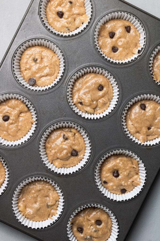 healthy banana protein muffin batter in lined muffin tins before being baked