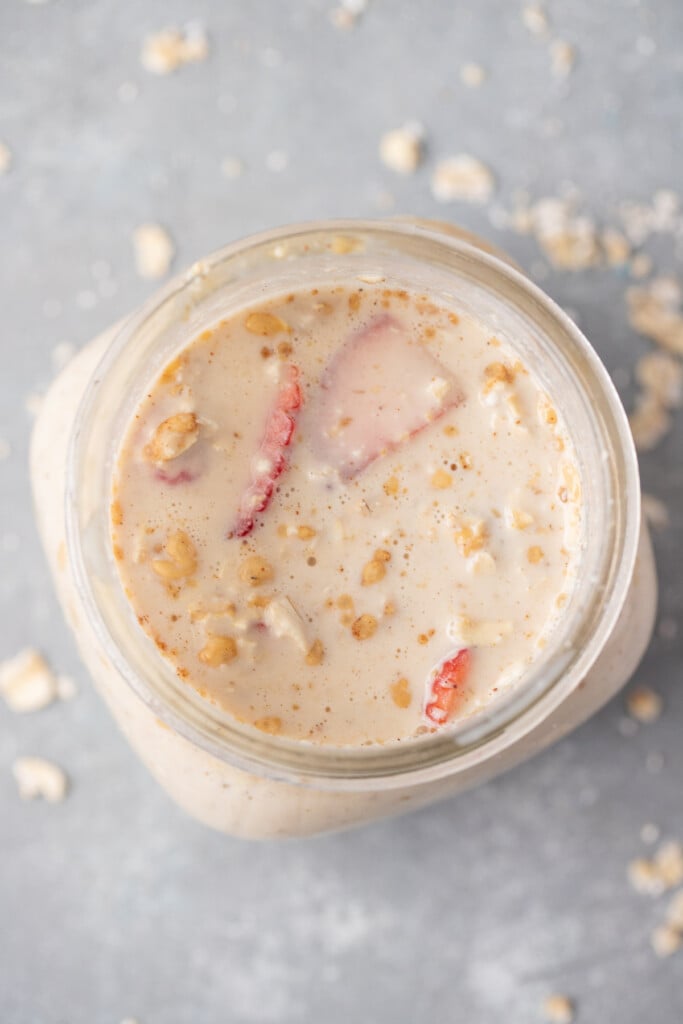 An overhead shot of Protein Overnight Oats in a mason jar on a grey background