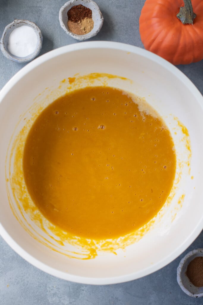Ingredients for healthy pumpkin muffins being mixed together in a bowl
