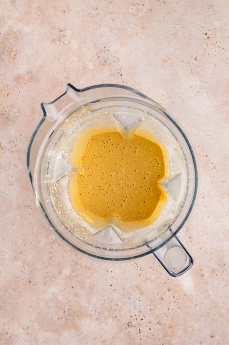 Pumpkin protein smoothie in a blender after blending smooth.