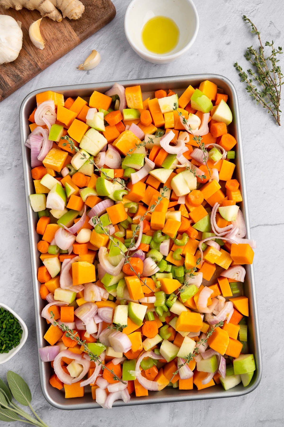 Vegetables for roasted butternut squash soup on a baking sheet before roasting
