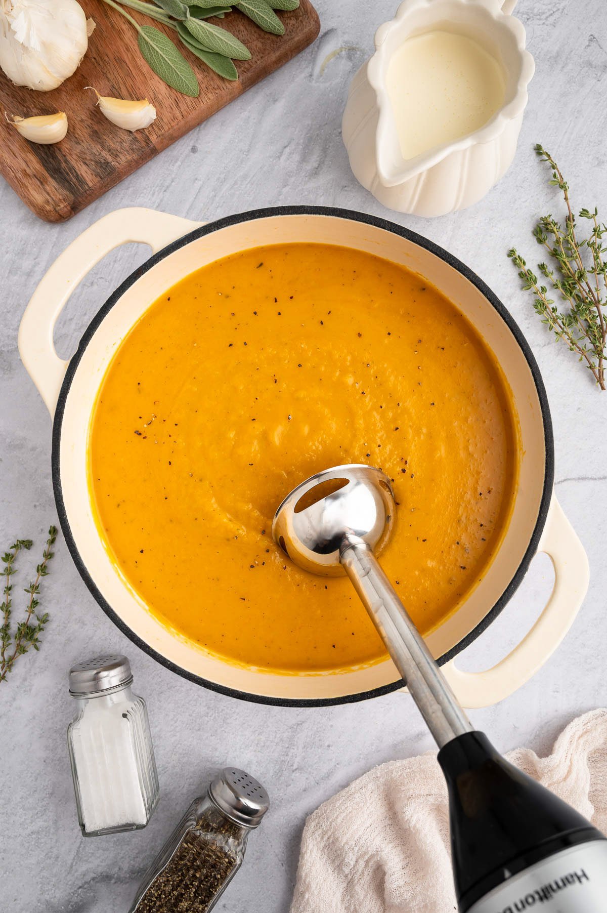 An overhead shot of a pot of roasted butternut squash soup while blending