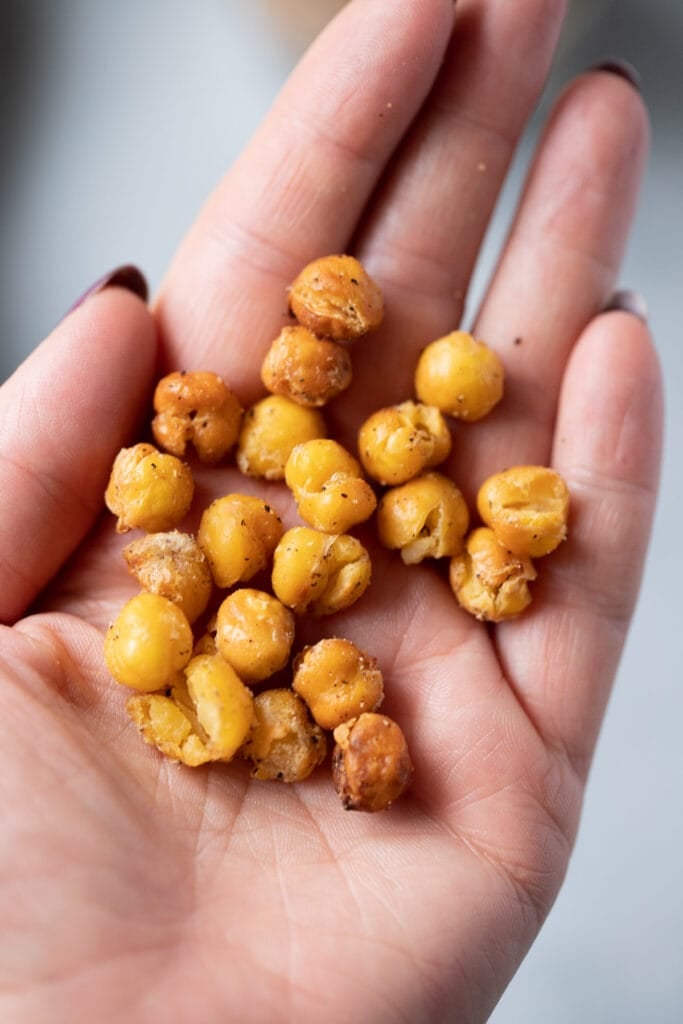 Roasted Garbanzo beans in a hand being held up to the camera 