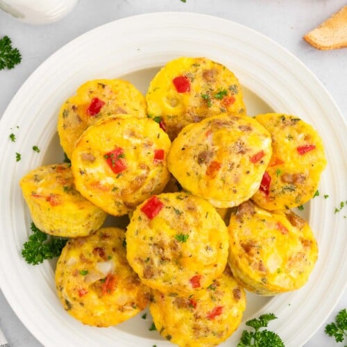 Sausage and Egg muffins piled on a white plate.
