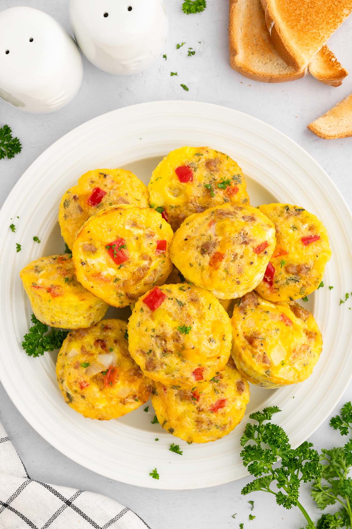 Sausage and Egg muffins piled on a white plate.
