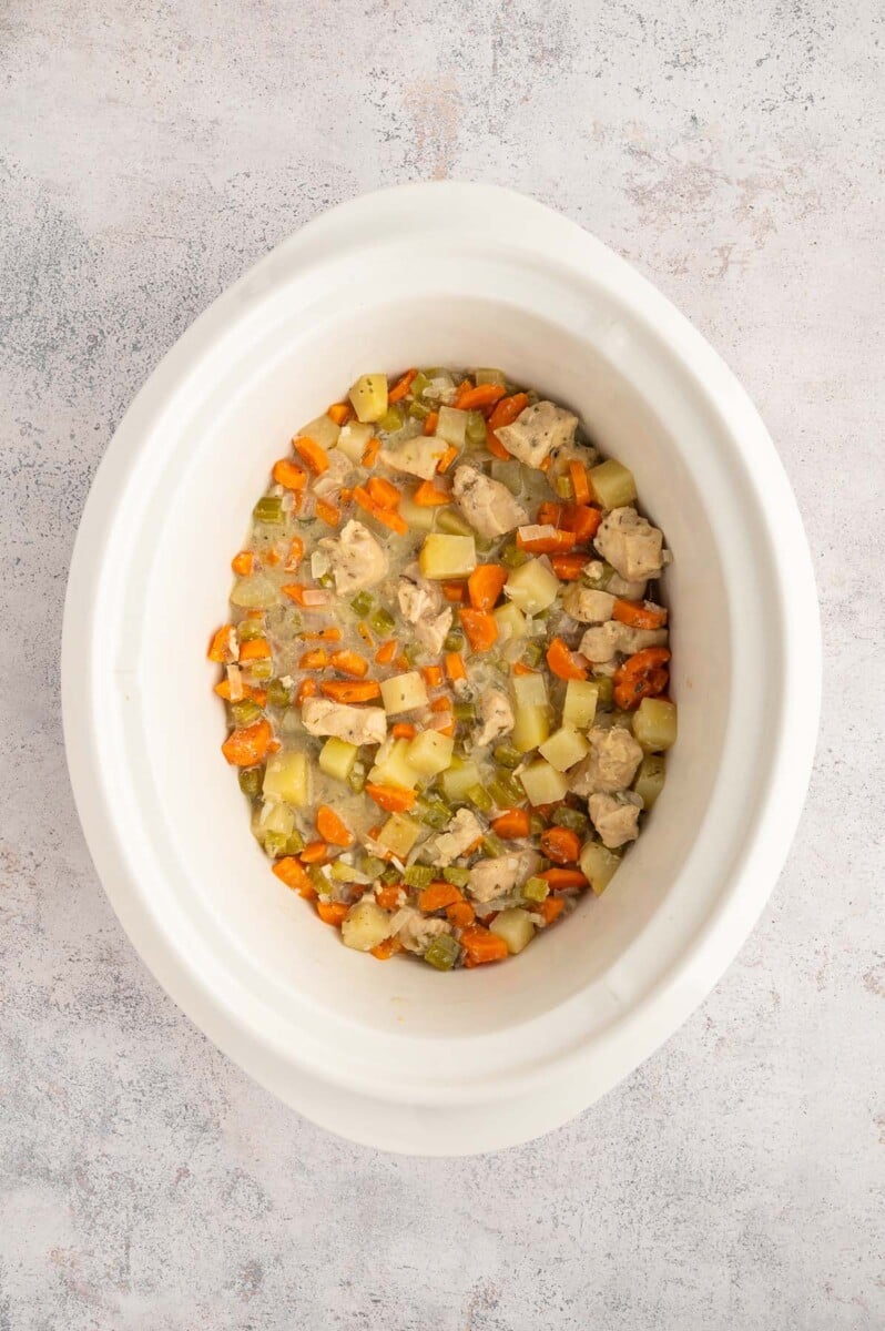 A crockpot of chicken stew after cooking and being mixed