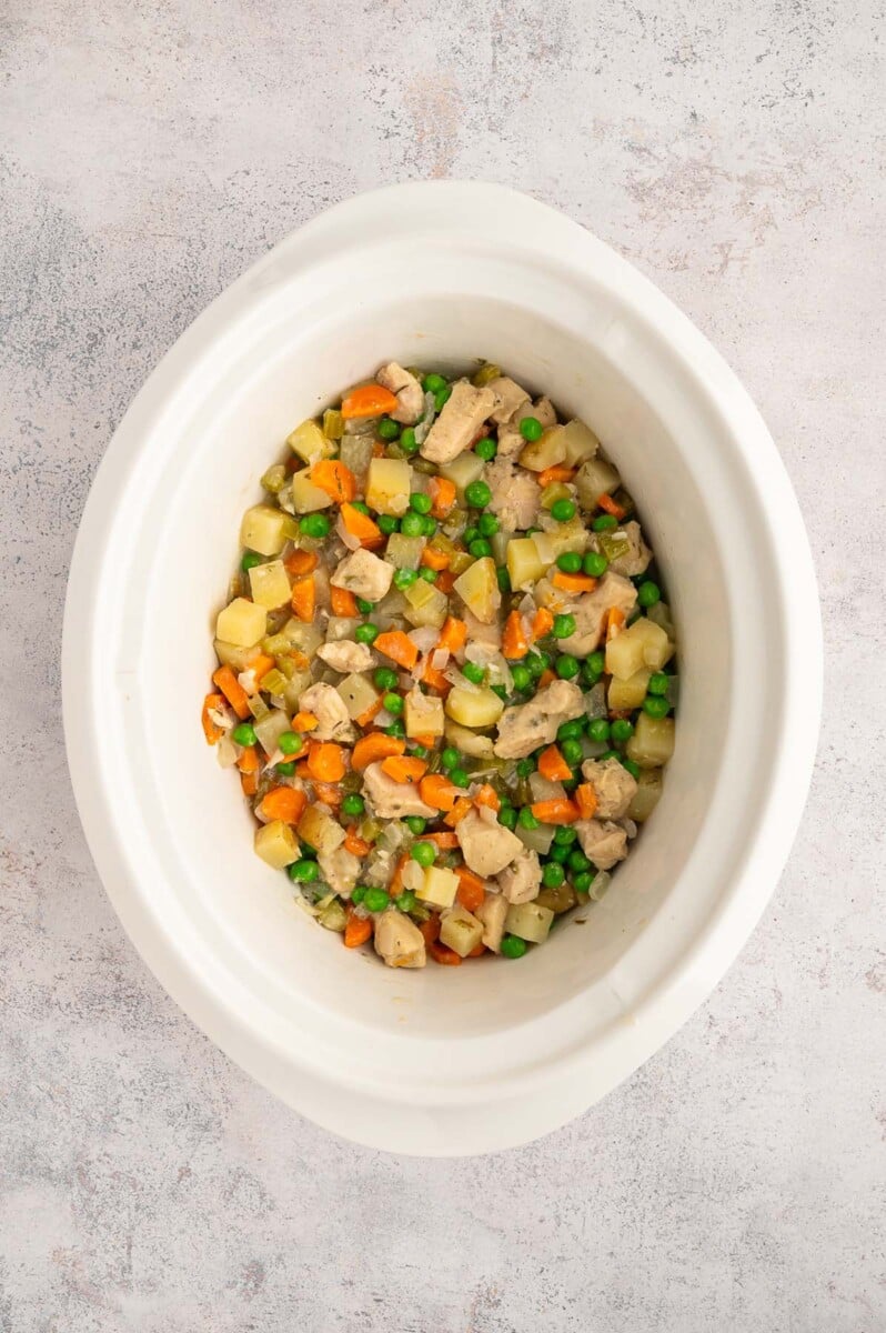 Slow Cooker Chicken Stew with peas stirred in it in a crockpot