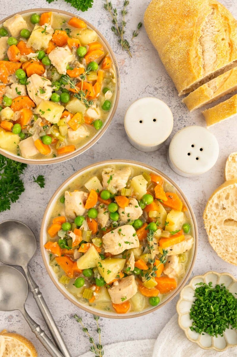 A close up of Slow Cooker Chicken Stew in a grey bowl on a grey background