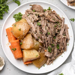 A plate of crock pot pot roast with potatoes and carrots