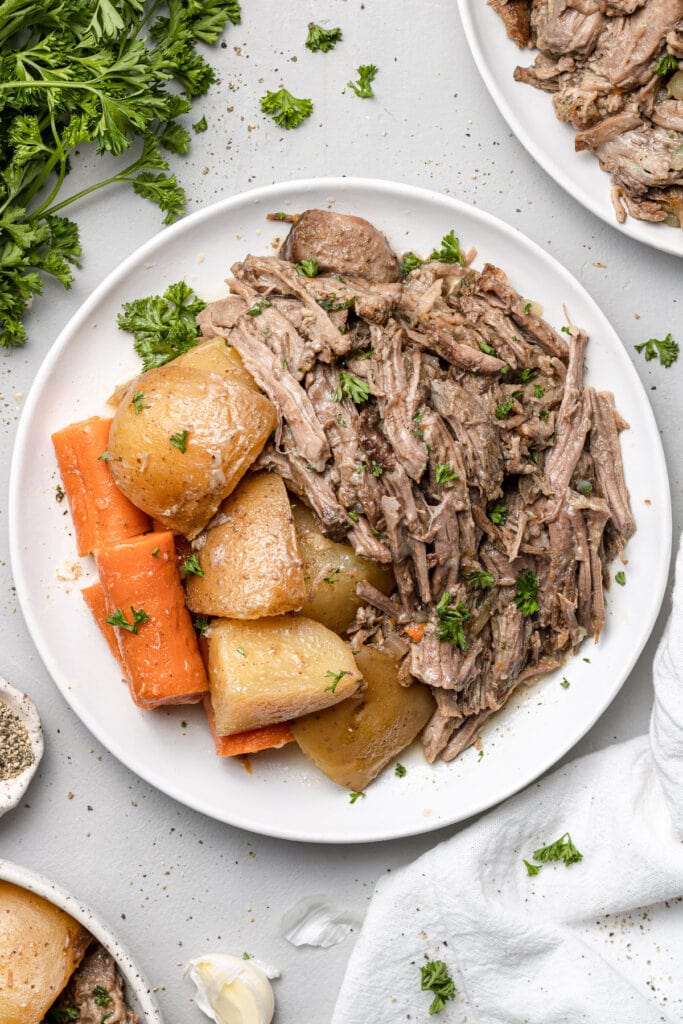 A plate of crock pot pot roast with potatoes and carrots