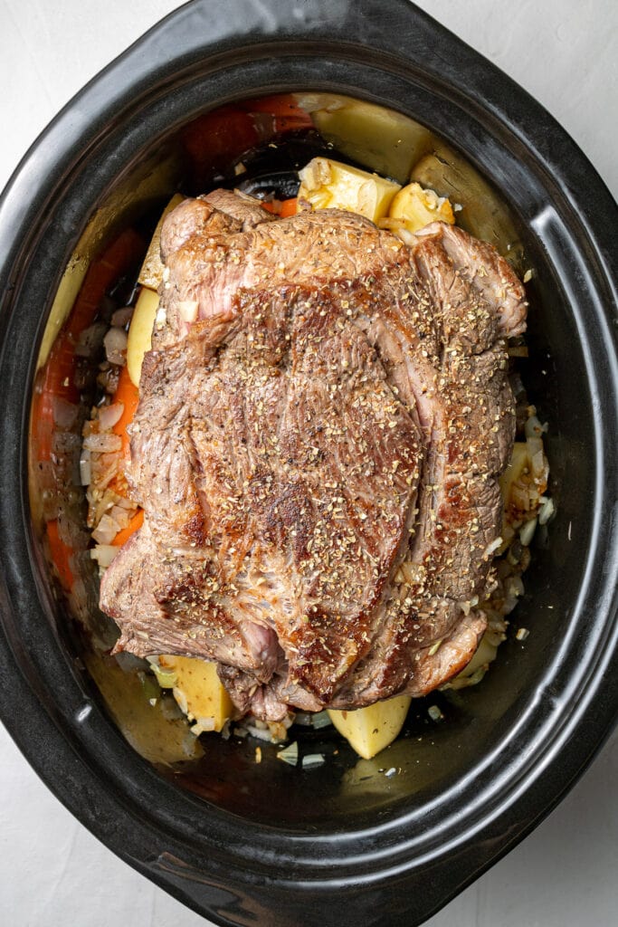 Ingredients for slow cooker pot roast in a crock pot, uncooked