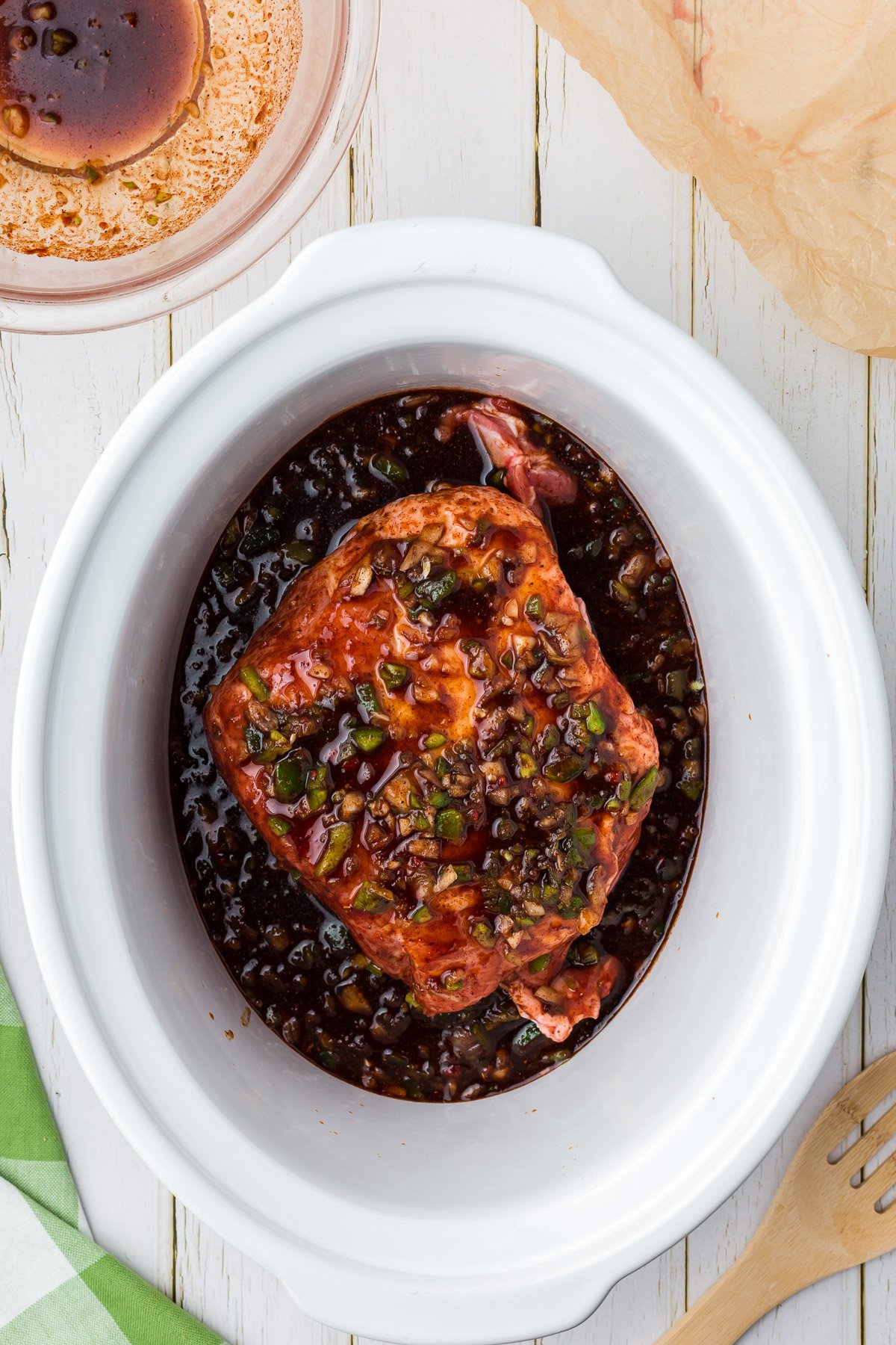 Sauce and pork butt in a white crockpot for slow cooker pulled pork