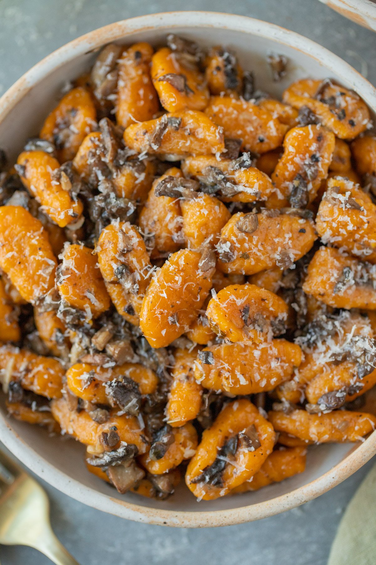 An overhead shot of sweet potato gnocchi on a grey background