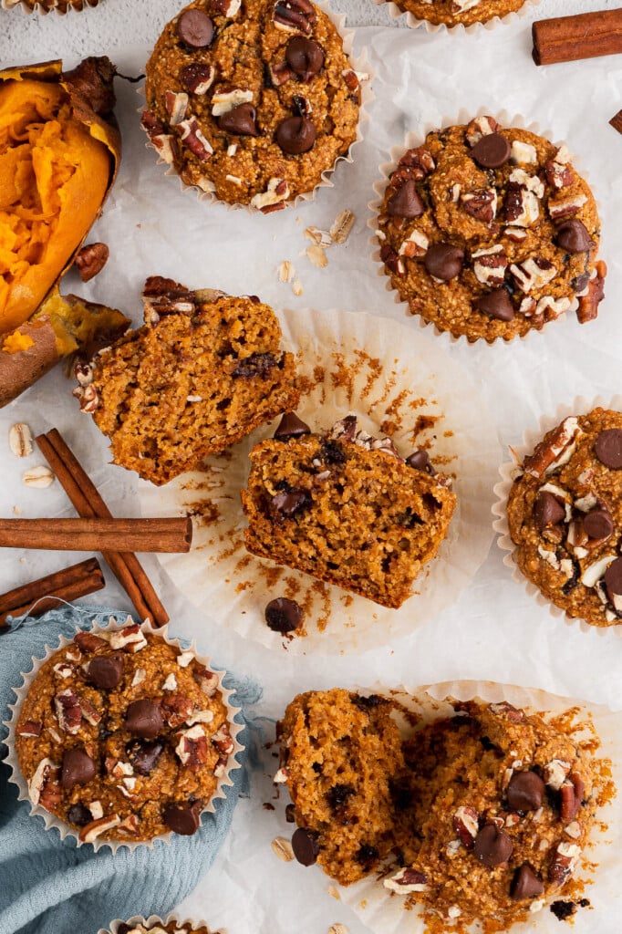 Sweet potato muffins on a white background with a blue towel and cinnamon sticks on the side