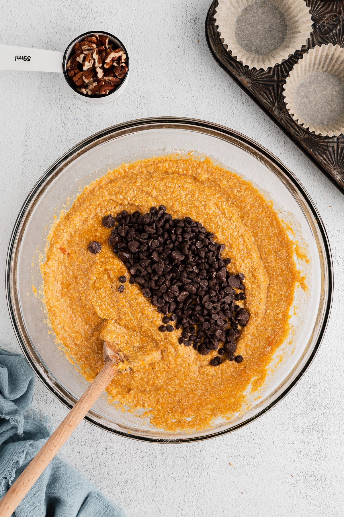 chocolate chips being added to the batter for sweet potato muffins