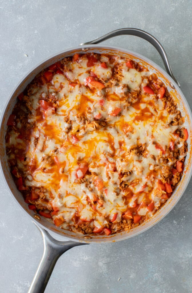 An overhead shot of a taco skillet in a large pan on a grey background