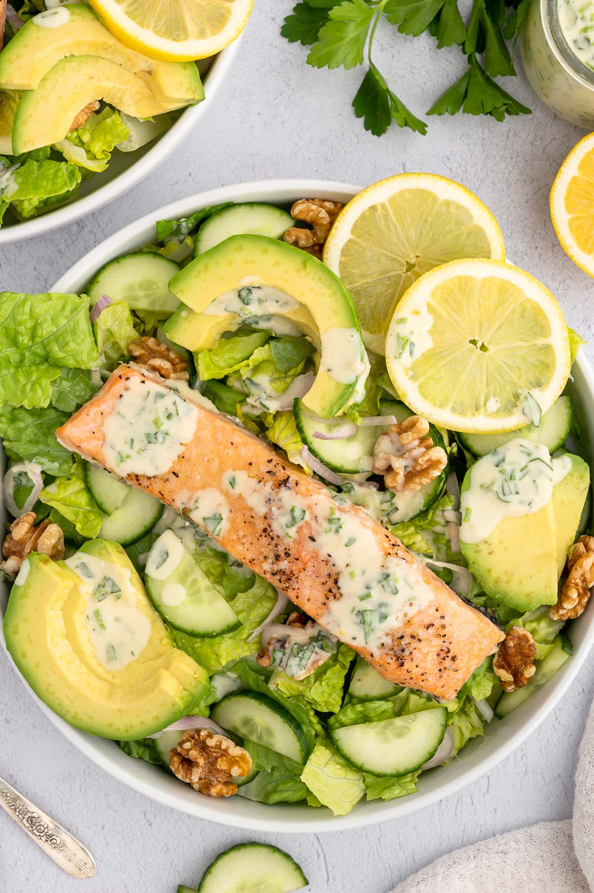 An overhead shot of a salmon salad topped with healthy tahini dressing.