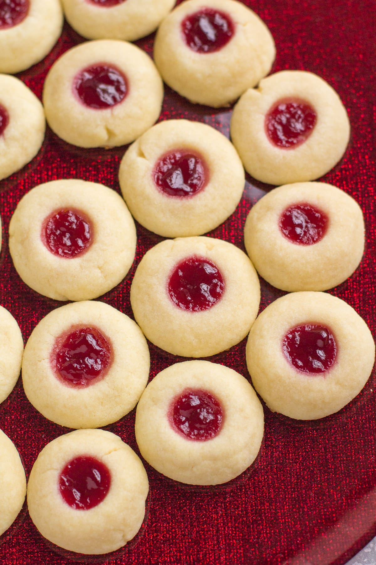 A close up image of Thumbprint Cookies on a bright red plate