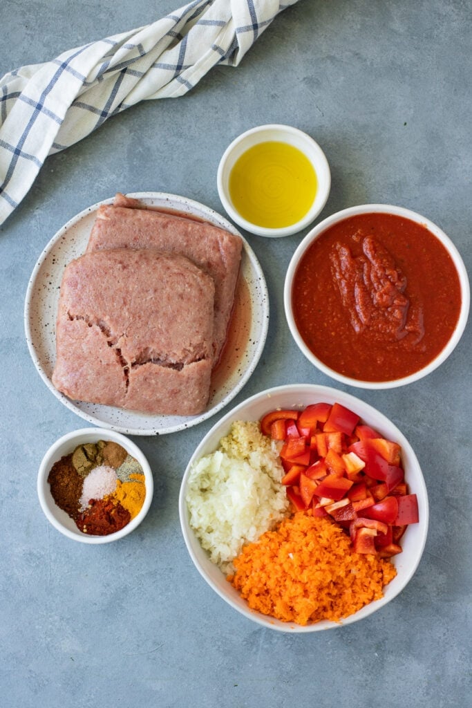 Ingredients for Paleo Turkey Chili in small white bowls on a grey background