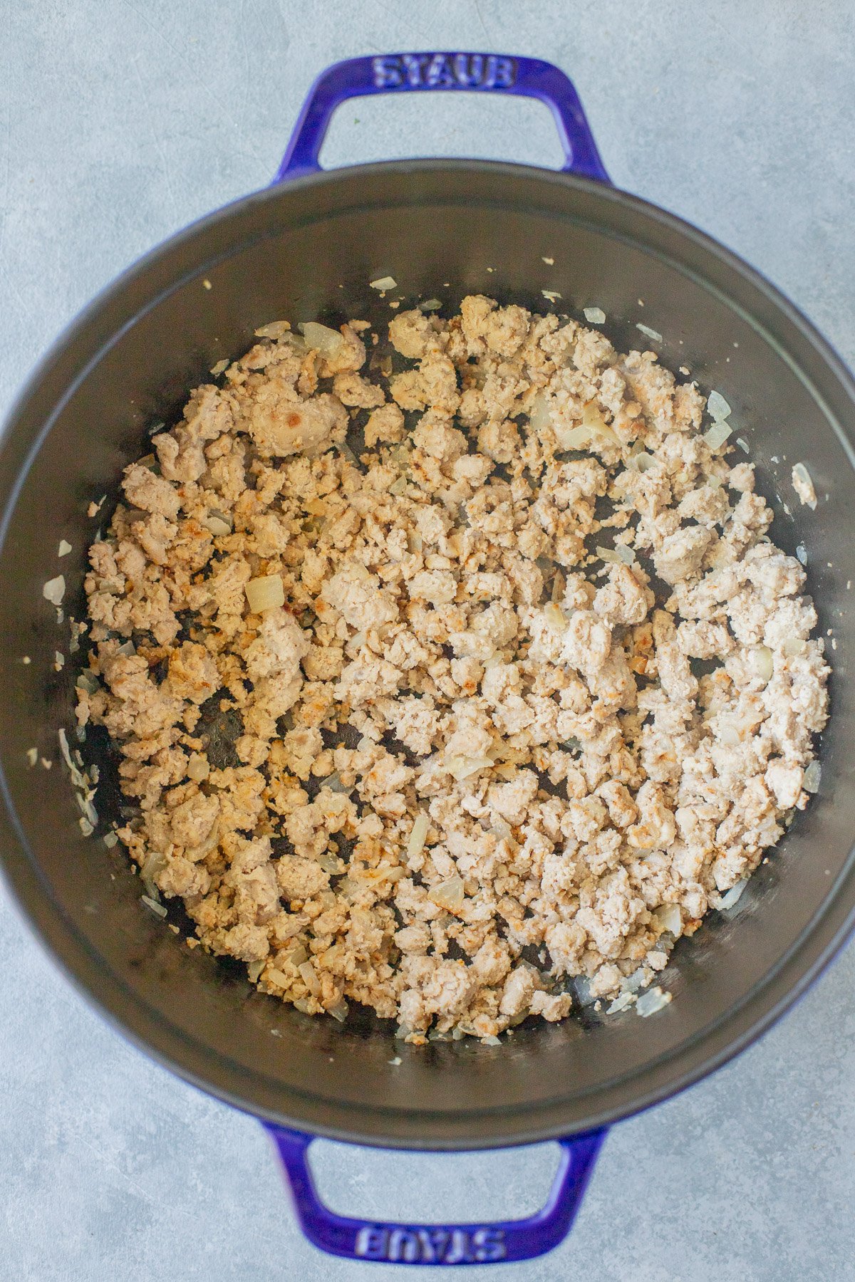 Ground turkey, onions, and garlic in a pot for healthy turkey chili