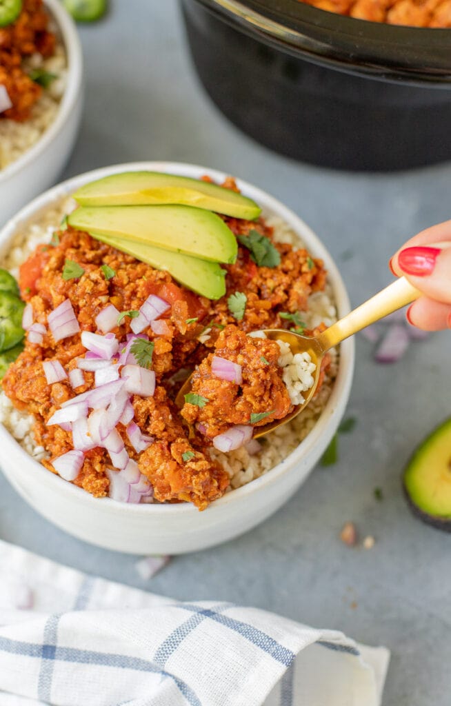 a spoon taking a bite out of turkey chili made in the crockpot