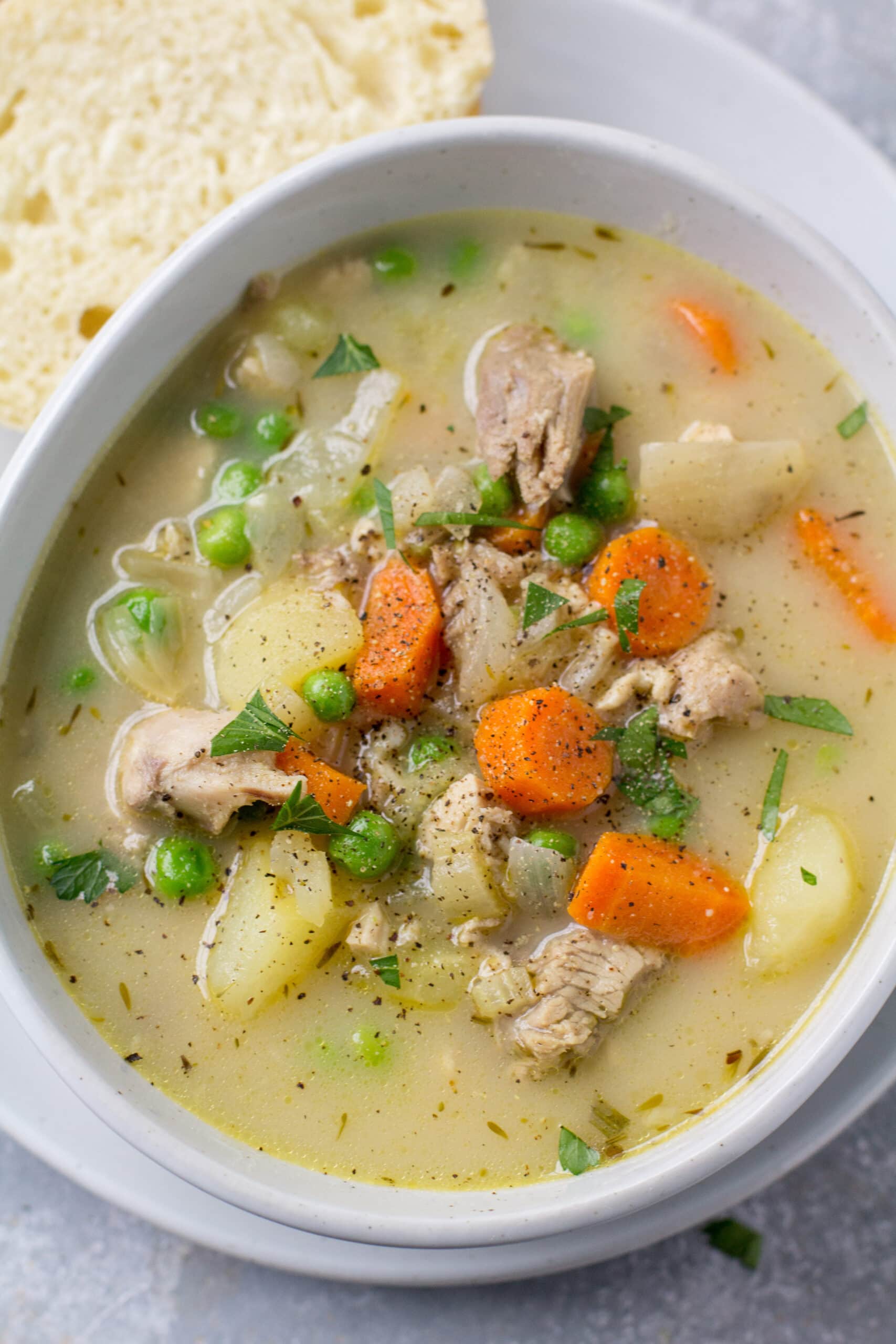 A cozy bowl of Healthy Turkey Pot Pie Soup with bread off to the side
