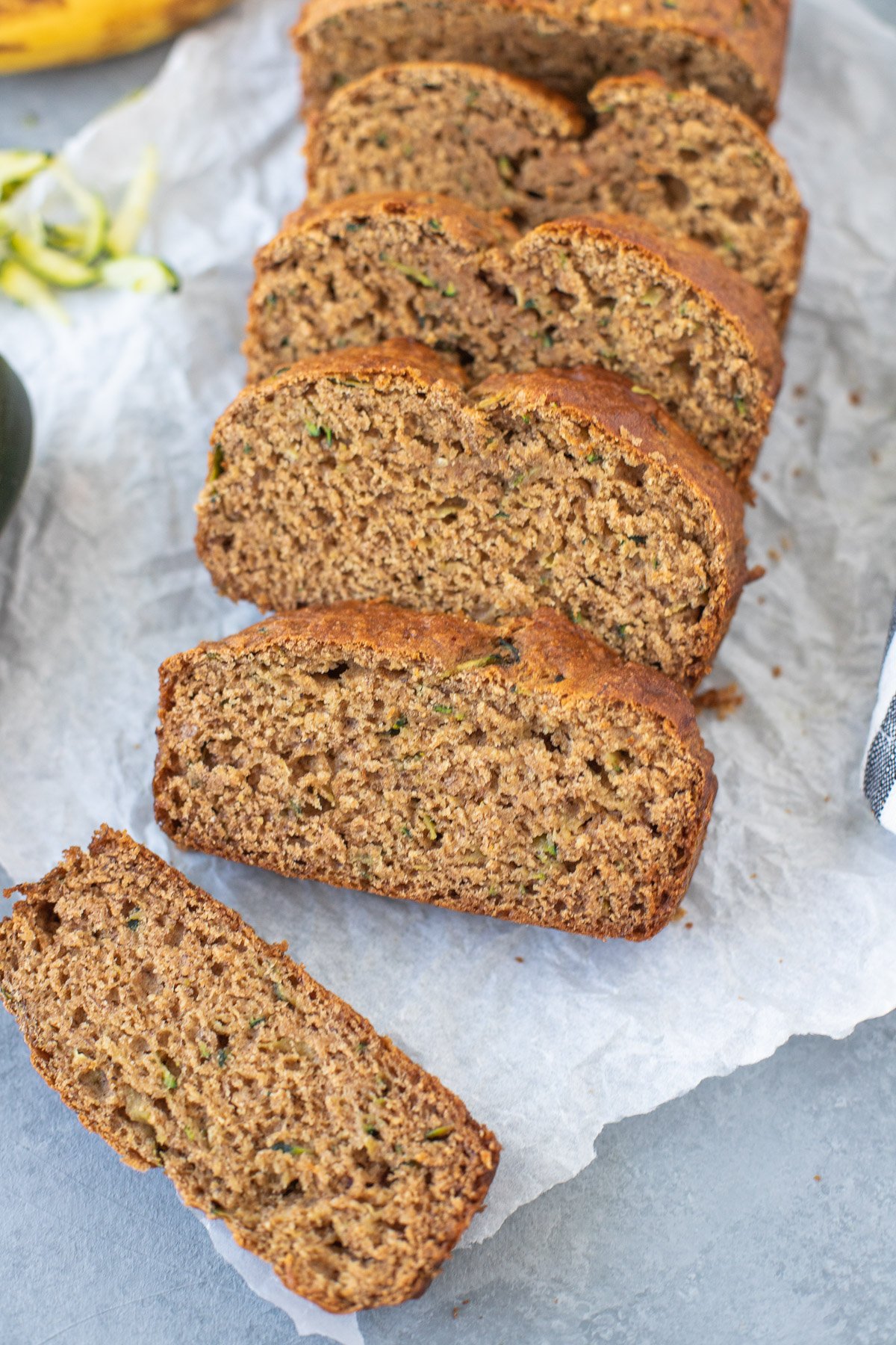 Zucchini Banana Bread Recipe sliced on a piece of parchment paper