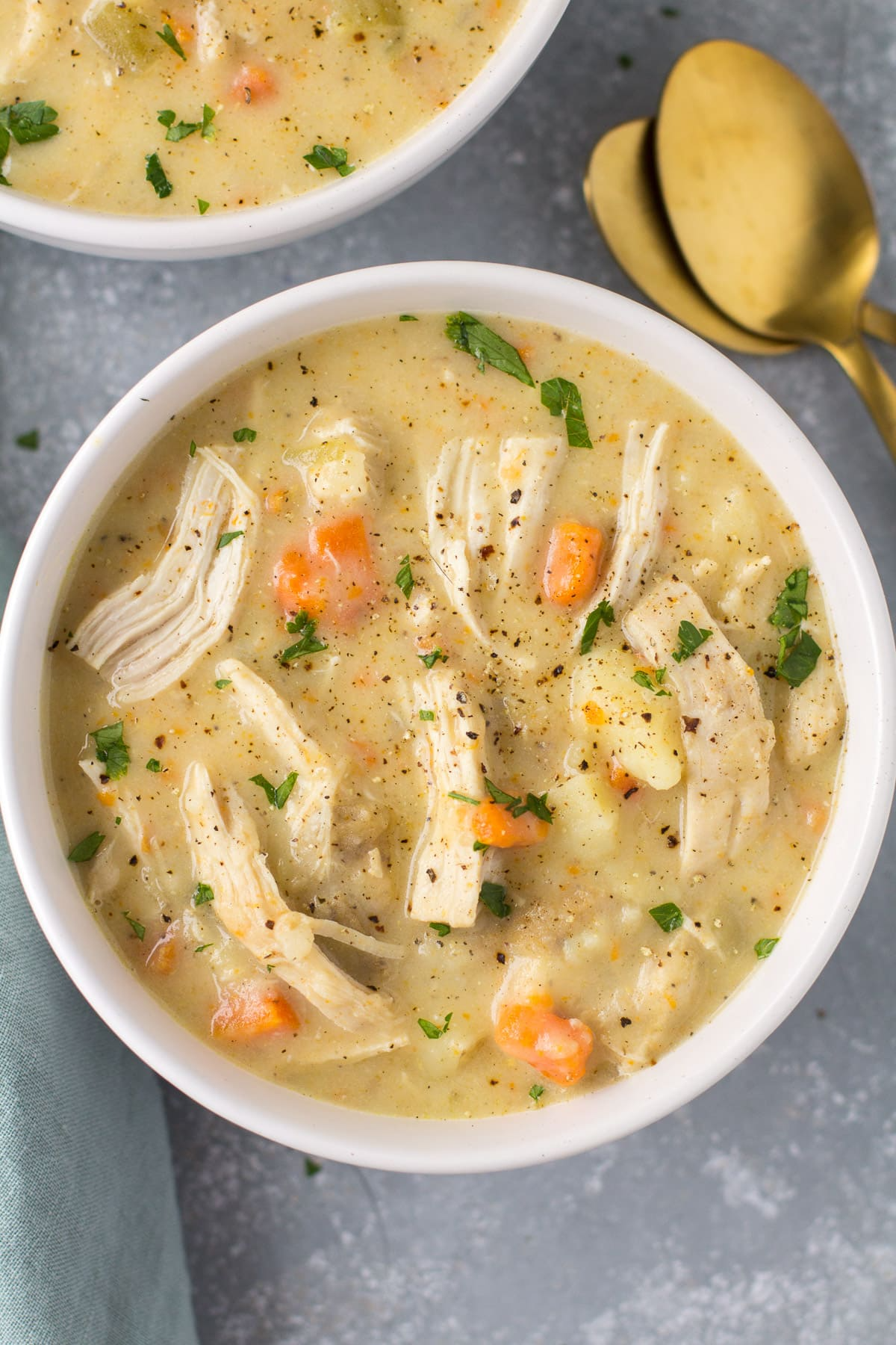 High Protein Chicken Pot Pie Soup in a white bowl on a grey background. 