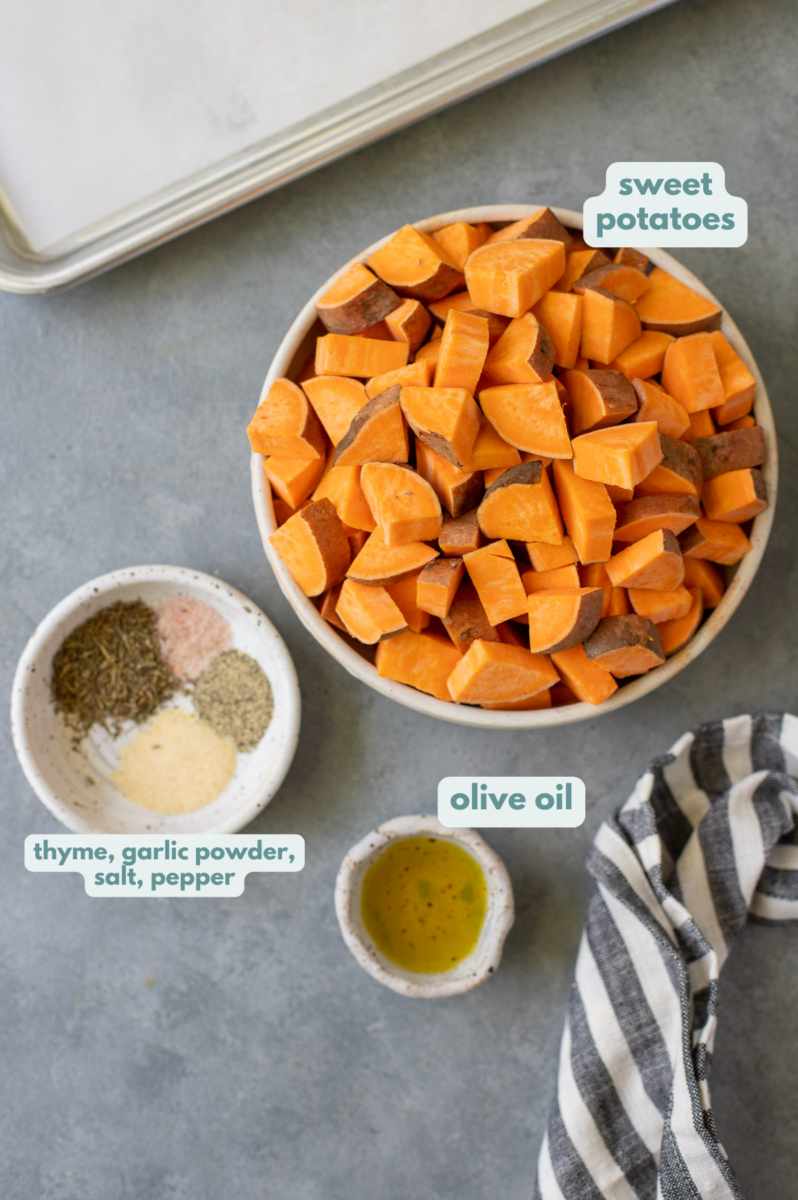 Ingredients for roasted sweet potato cubes in white bowls on a grey background: sweet potatoes, olive oil, salt, pepper, garlic powder, thyme