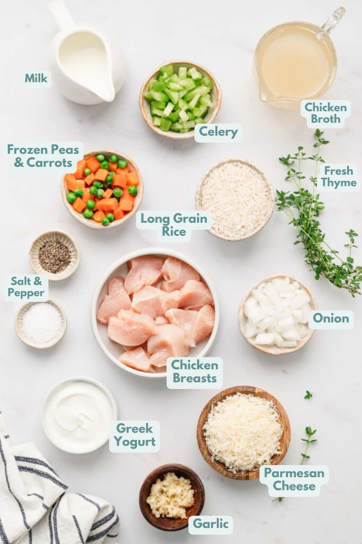 Ingredients for crockpot chicken and rice in small bowls: long grain white rice, chicken breast, salt, pepper, onion, garlic, celery, frozen peas & carrots mix, fresh thyme, chicken broth, greek yogurt, parmesan cheese, milk