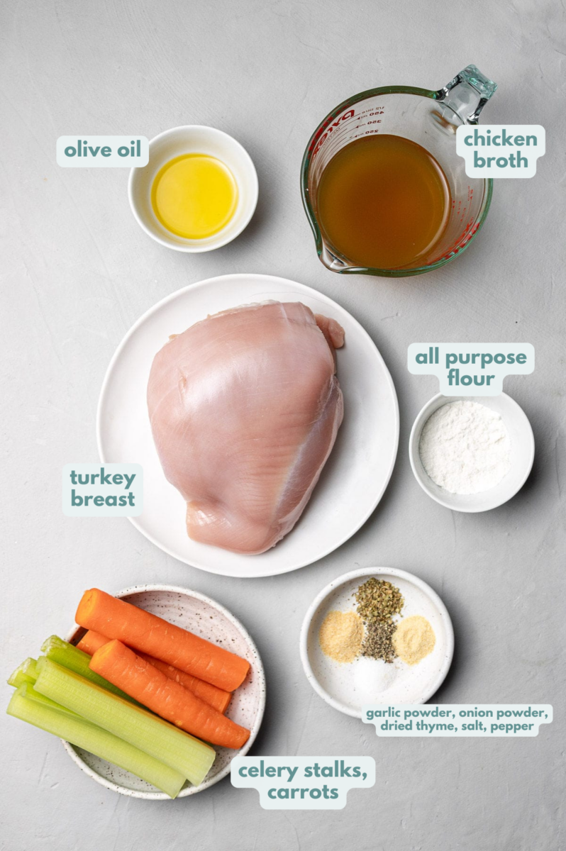 Ingredients for Slow Cooker Turkey Breast on white plates: boneless turkey breast, celery, carrots, vegetable stock, olive oil, garlic powder, onion powder, dried thyme, salt + pepper