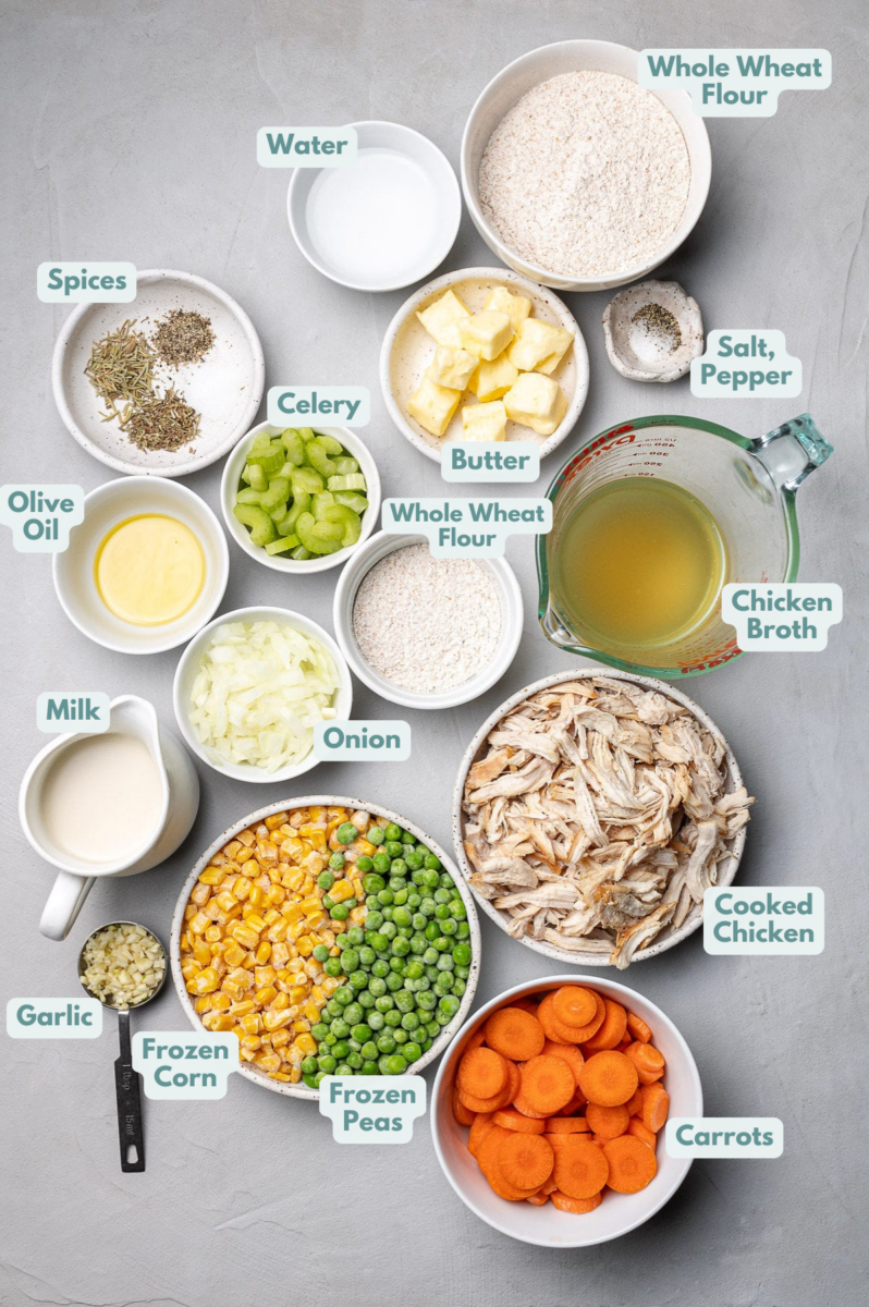 Ingredients for Healthy chicken pot pie in white bowls: Crust: Whole wheat flour, butter, salt, pepper, water Filling: olive oil, onion, garlic, carrots, celery, salt, pepper, dried thyme, dried rosemary, whole wheat flour, chicken broth, milk, cooked chicken, frozen peas, frozen corn