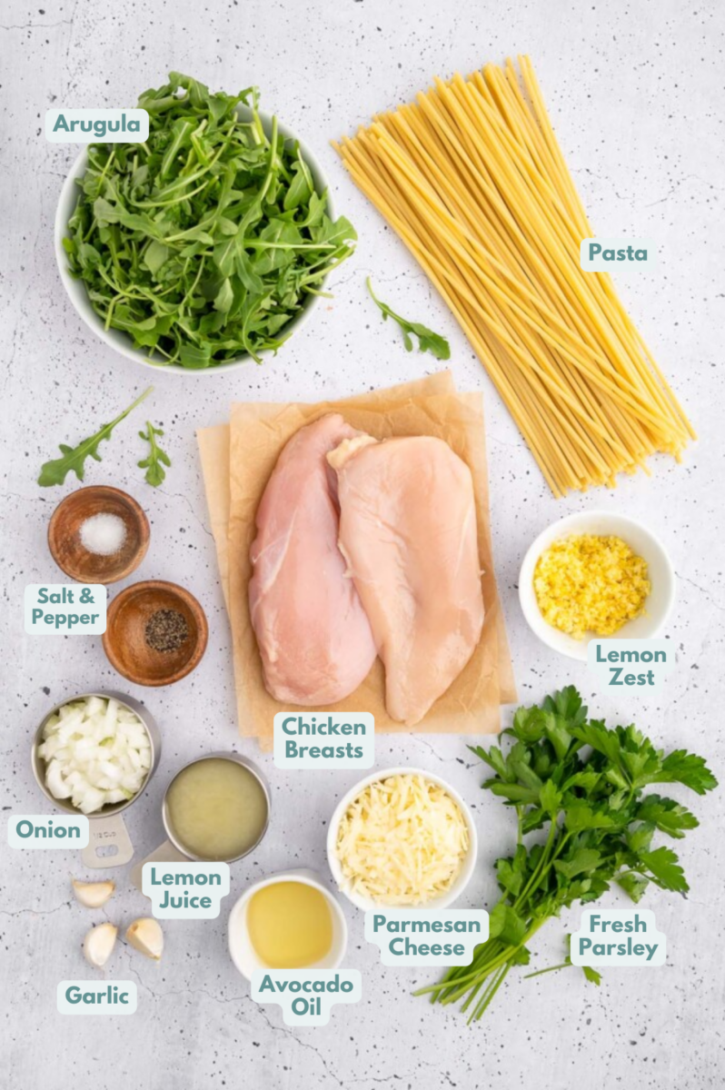 Ingredients for lemon chicken pasta in small bowls: avocado oil, chicken breasts, salt, pepper, garlic, onion, fresh parsley, lemon juice, lemon zest, parmesan cheese, pasta water, arugula, bucatini pasta