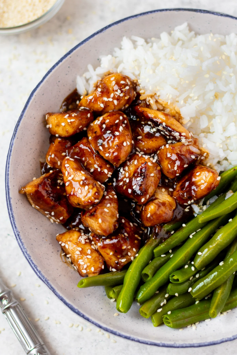 a grey plate with high protein healthy sesame chicken, white rice + green beans