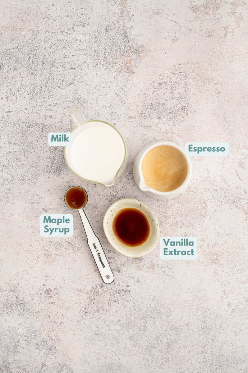 Ingredients for healthy vanilla latte in small bowls: espresso, milk, vanilla extract, maple syrup